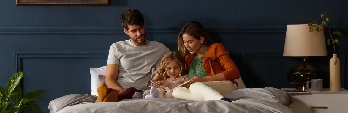 family sitting on bed